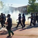 men in black uniform standing on road during daytime