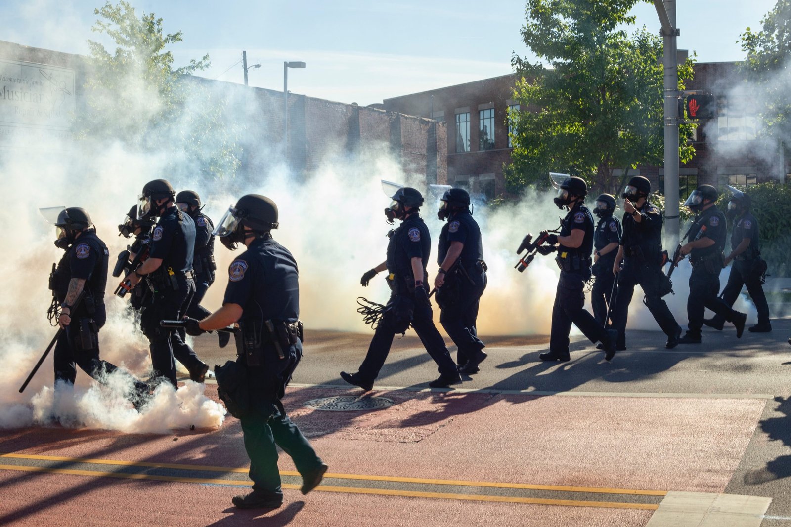 men in black uniform standing on road during daytime