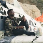 man in black and brown camouflage uniform sitting on white plane