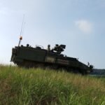 green army tank parking on green grass ground