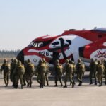 people in black and brown uniform standing on white field during daytime