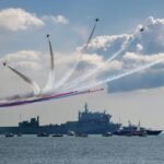 white and red ship on sea under white clouds