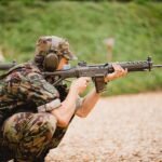 man in green and brown camouflage army suit holding rifle