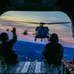 two soldiers on flying airplane with strap on back